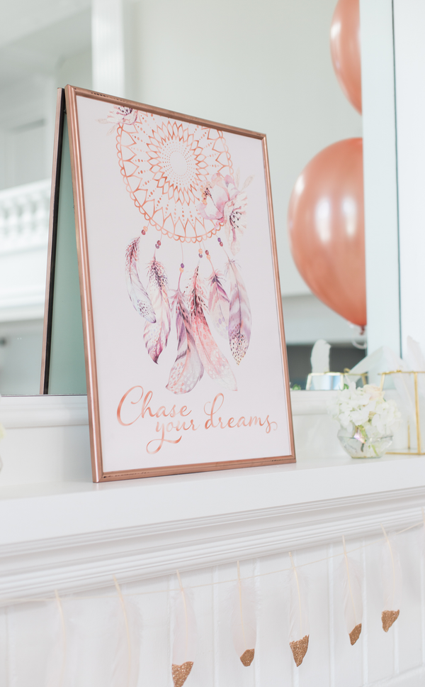 Dream catcher artwork that reads "Chase Your Dreams" in rose gold frame at kids birthday party